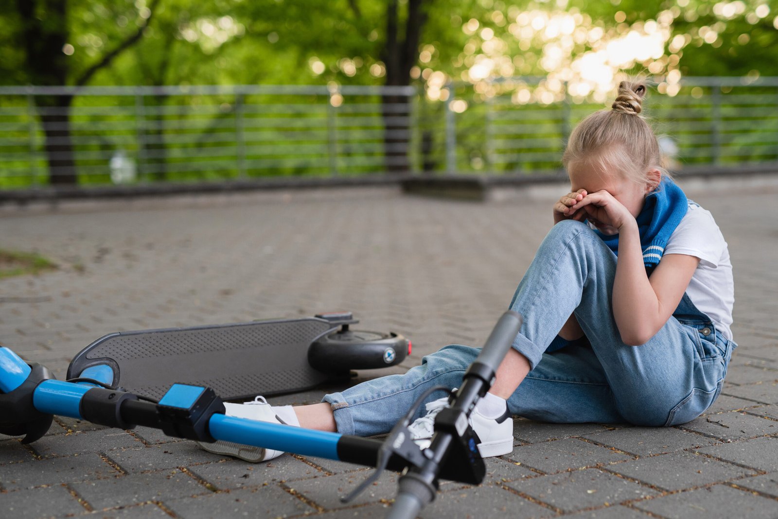 Electric scooter accident - girl suffering of pain  after knee injury in city park